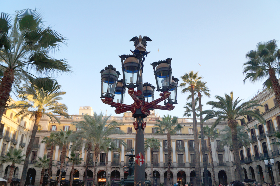 Hema_pose_ses_valises_barcelone_cityguide_placa_reial_lampadaire